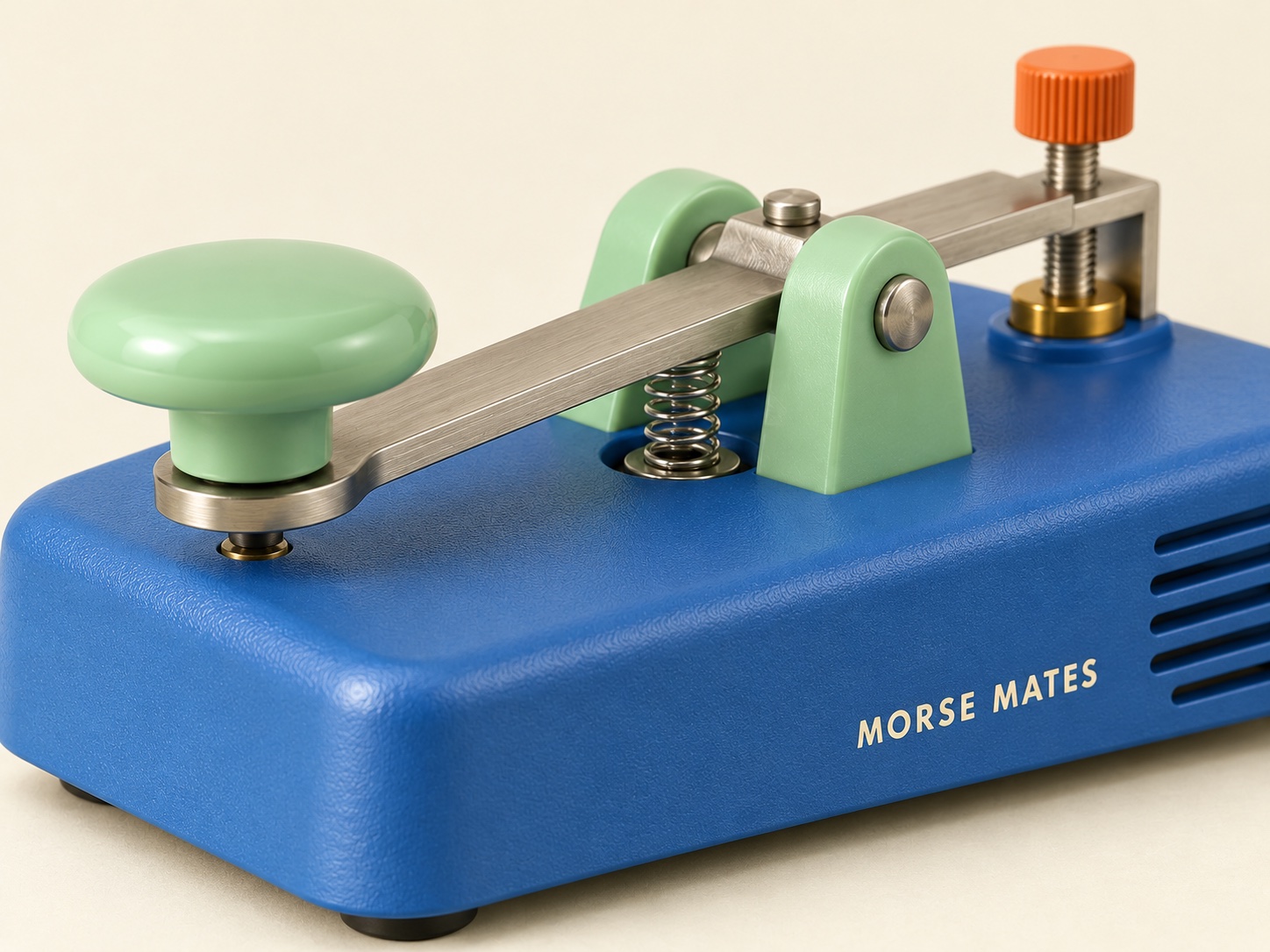 Close-up of the mint finger button, brushed-metal lever, spring, and contact on the blue Morse Mates key